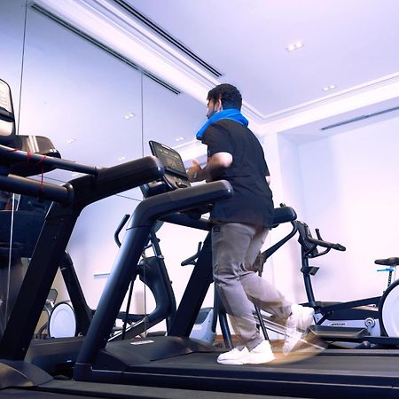 Makarem Ajyad Makkah Hotel Mecca Екстер'єр фото The photo shows a person exercising on a treadmill in a modern gym or fitness room. The individual is wearing a blue neck support while jogging on the treadmill, which is set against a backdrop of large mirrors. There are also additional exercise equ