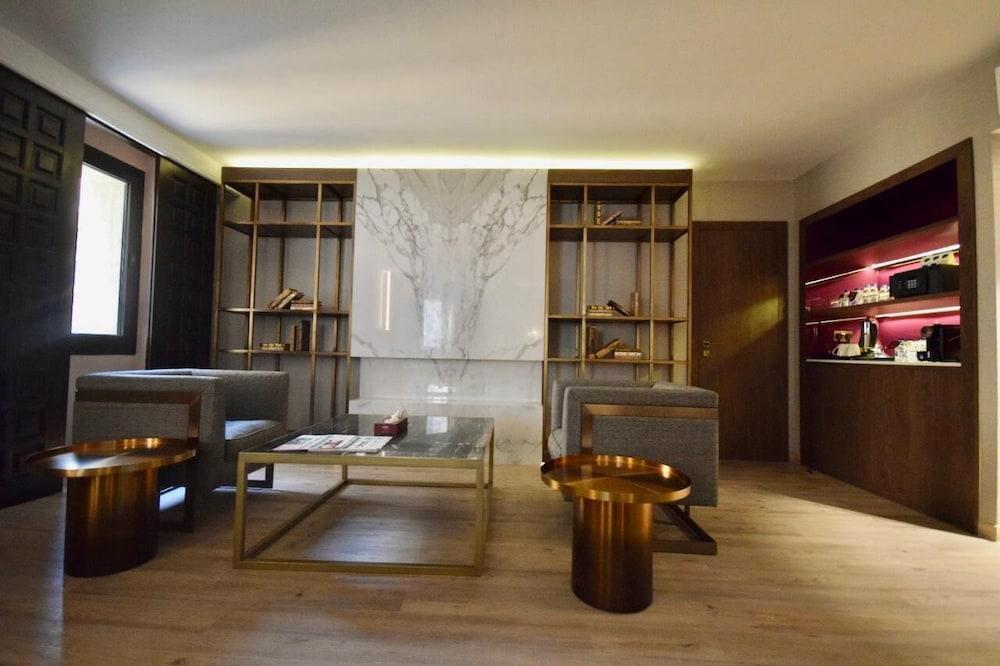 Makarem Ajyad Makkah Hotel Mecca Екстер'єр фото The photo shows a modern and stylish interior space, likely a living room or lounge area. On the left side, there are two comfortable gray armchairs positioned toward the center. A glass coffee table sits between them, featuring a few magazines or bo