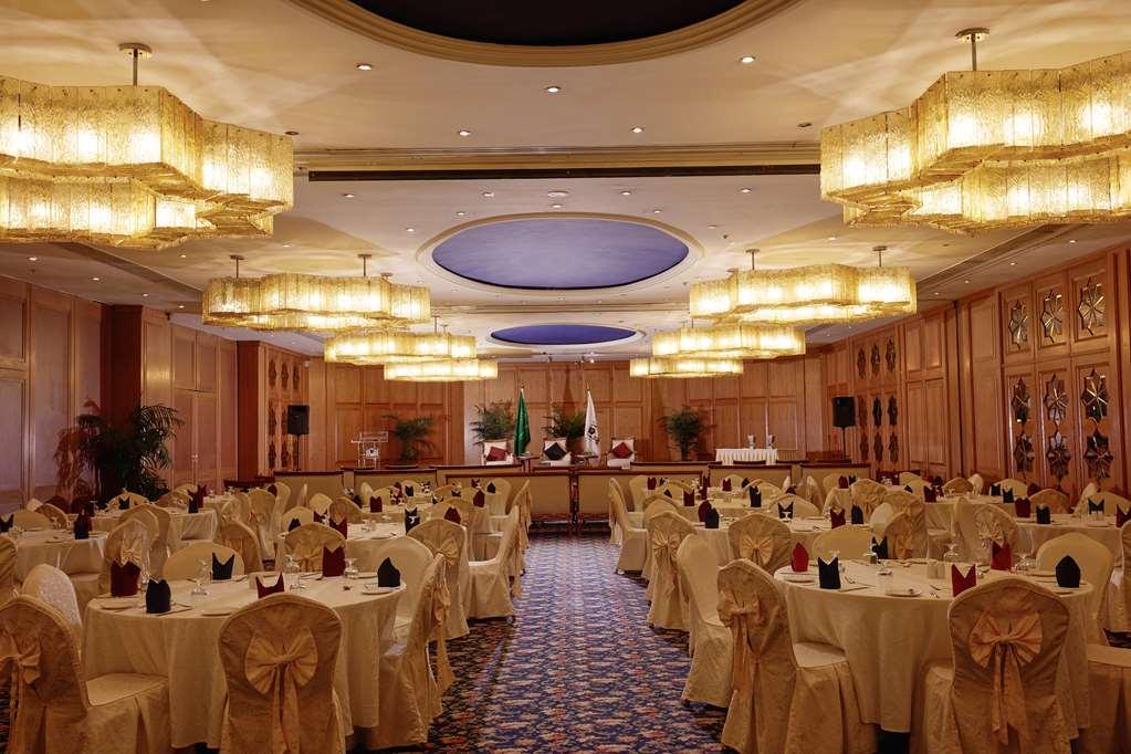 Makarem Ajyad Makkah Hotel Mecca Зручності фото The photo shows an elegantly arranged banquet or conference room. There are several round tables covered with light-colored tablecloths and adorned with decorative napkins. The seating is also stylish, with chairs featuring matching coverings. The ro