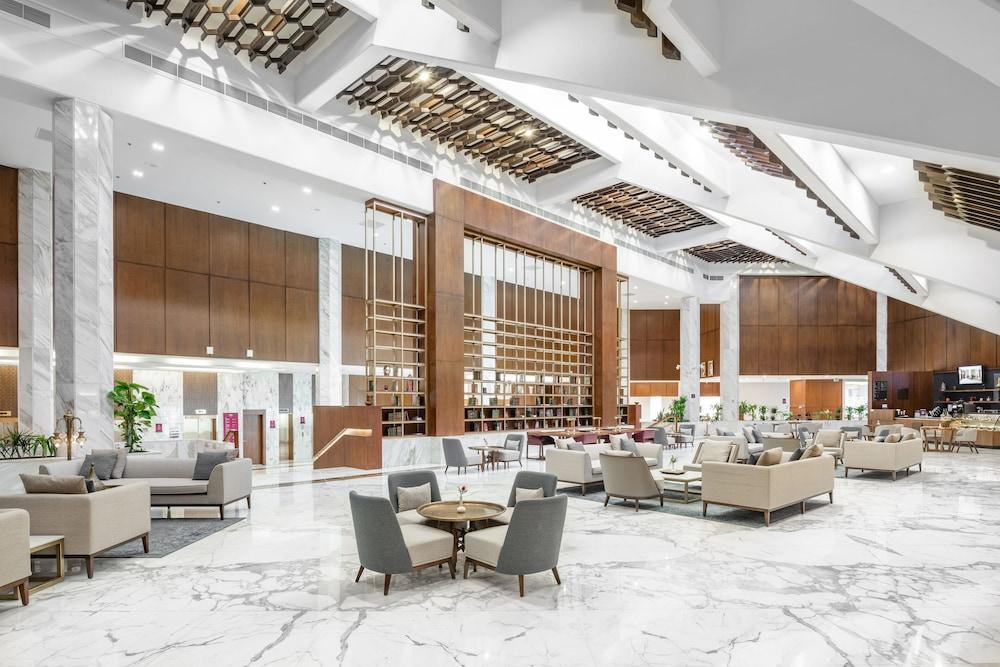 Makarem Ajyad Makkah Hotel Mecca Екстер'єр фото The photo shows a spacious and modern hotel lobby. It features a high ceiling with an elegant design, incorporating wooden accents and contemporary lighting. The floor is made of white marble, creating a bright and open atmosphere. 

In the foregroun