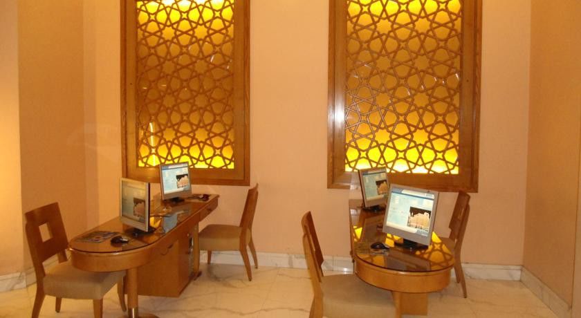 Makarem Ajyad Makkah Hotel Mecca Екстер'єр фото The image shows a room with a warm, inviting atmosphere, featuring two wooden desks equipped with computers. Each desk has a chair positioned in front of it. The walls are adorned with decorative panels that exhibit intricate patterns, illuminated by