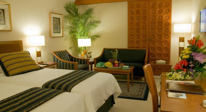 Makarem Ajyad Makkah Hotel Mecca Екстер'єр фото The photo shows a cozy hotel room that features two single beds with white linens and dark green and striped blankets. There is a decorative rug on the floor. Against one wall, there is a large wooden partition with a distinctive geometric pattern. T