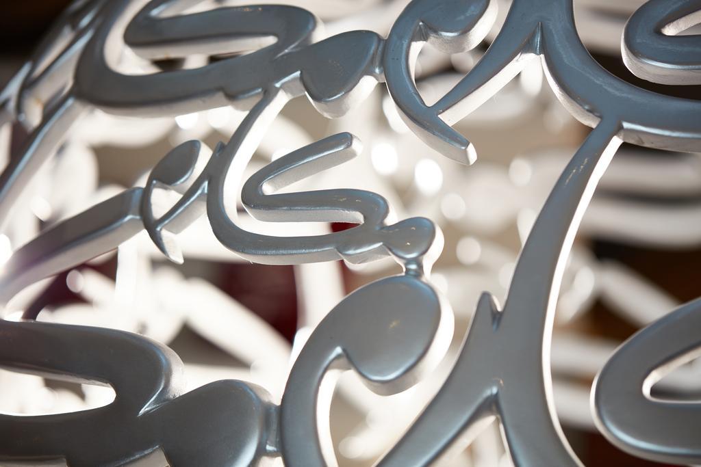 Makarem Ajyad Makkah Hotel Mecca Екстер'єр фото The photo shows a close-up of a white, artistic structure or piece of decor that features intricate, stylized lettering. The letters are intertwined and have a fluid, modern design. The focus on the details reveals the elegance of the curves and shap